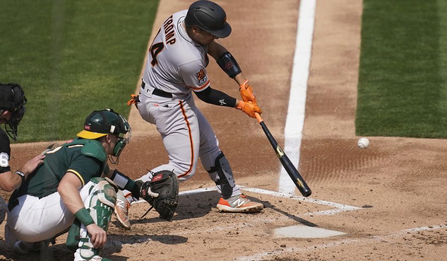 San Francisco Giants&#39; Chadwick Tromp, right, hits a two-run home run in front of Oakland Athletics catcher Sean Murphy during the third inning of a baseball game in Oakland, Calif., Sunday, Sept. 20, 2020. (AP Photo/Jeff Chiu)