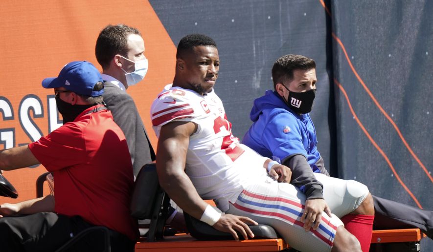 New York Giants running back Saquon Barkley (26) is carted to the locker room after being injured during the first half of an NFL football game against the Chicago Bears in Chicago, Sunday, Sept. 20, 2020. (AP Photo/Nam Y. Huh)