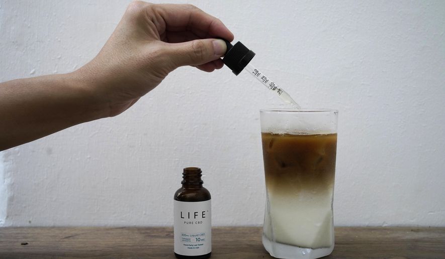 An employee adds drops of water-soluble CBD, or cannabidiol, an essential component of medical marijuana, into a coffee glass at the Found Cafe in Hong Kong on Sept. 13, 2020. Cannabis, also known as marijuana, in Hong Kong may be illegal, but the new Found Cafe is offering a range of food and drinks that contain parts of the cannabis plant without breaking any local laws. (AP Photo/Vincent Yu)