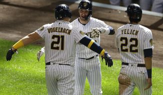 Milwaukee Brewers&#39; Daniel Vogelbach, left, is congratulated by Ryan Braun, center,  and Christian Yelich, right, after hitting a three-run home run during the sixth inning of a baseball game against the Kansas City Royals Sunday, Sept. 20, 2020, in Milwaukee. (AP Photo/Aaron Gash)
