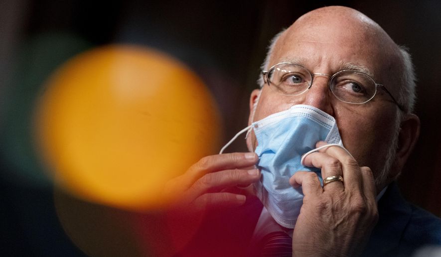In this Wednesday, Sept. 16, 2020, file photo, Centers for Disease Control and Prevention Director Dr. Robert Redfield puts his mask back on after speaking at a Senate Appropriations subcommittee hearing on a &quot;Review of Coronavirus Response Efforts,&quot; on Capitol Hill, in Washington. The CDC has stirred confusion, by posting, and then taking down, an apparent change in its position on how easily the coronavirus can spread through the air. (AP Photo/Andrew Harnik, Pool, File)