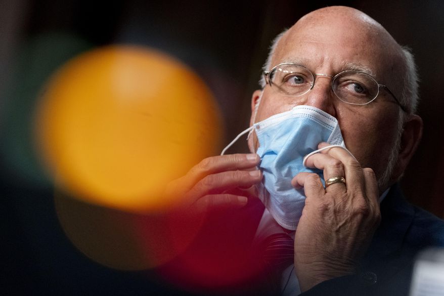 In this Wednesday, Sept. 16, 2020, file photo, Centers for Disease Control and Prevention Director Dr. Robert Redfield puts his mask back on after speaking at a Senate Appropriations subcommittee hearing on a "Review of Coronavirus Response Efforts," on Capitol Hill, in Washington. The CDC has stirred confusion, by posting, and then taking down, an apparent change in its position on how easily the coronavirus can spread through the air. (AP Photo/Andrew Harnik, Pool, File)