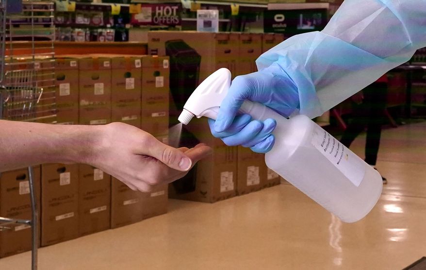 To prevent the spread of COVID-19, a customer gets a spray of hand sanitizer upon entering the Micro Center computer department store in Dallas, Monday, Sept. 21, 2020. Texas has begun allowing 75% capacity for retail and restaurant businesses in most of the state except a few counties on the U.S.-Mexico border. (AP Photo/LM Otero)