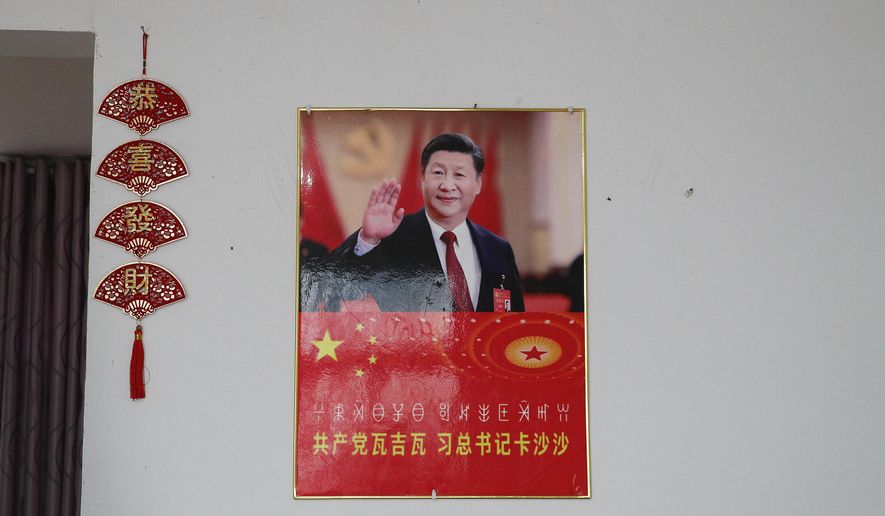 A poster showing an image of Chinese President Xi Jinping is displayed on a wall at a home of members of the Yi minority group in Xujiashan village in Ganluo County, southwest China's Sichuan province on Sept. 10, 2020. Communist Party Xi’s smiling visage looks down from the walls of virtually every home inhabited by members of the Yi minority group in a remote corner of China’s Sichuan province. Xi has replaced former leader Mao Zedong for pride of place in new brick and concrete homes built to replace crumbling traditional structures in Sichuan’s Liangshan Yi Autonomous Prefecture, which his home to about 2 million members of the group. (AP Photo/Andy Wong)