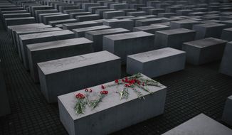 In this Tuesday, Jan. 27, 2015 fill photo, flowers lie on a concrete slab of the Holocaust Memorial to mark the International Holocaust Remembrance Day and commemorating the 70th anniversary of the liberation of the Nazi Auschwitz death camp in Berlin. The Department for Research and Information on Anti-Semitism Berlin, or RIAS documented 410 incidents in Berlin, more than two a day, in the first half of 2020, including physical attacks, property damage, threats, harmful behavior and anti-Semitic propaganda. (AP Photo/Markus Schreiber, File)