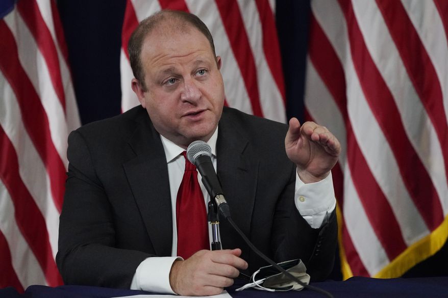 Colorado Governor Jared Polis makes a point about the increase in the state's new coronavirus cases over the past three weeks during a news conference Tuesday, Sept. 22, 2020, in Denver. (AP Photo/David Zalubowski)