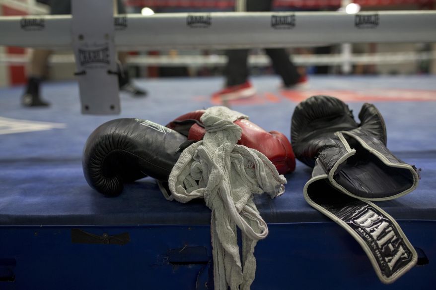 In this Friday, April 29, 2016 file photo, boxing gloves lie on a boxing ring as boxers work out at El Rayo boxing gym in Madrid, Spain. (AP Photo/Francisco Seco, File)