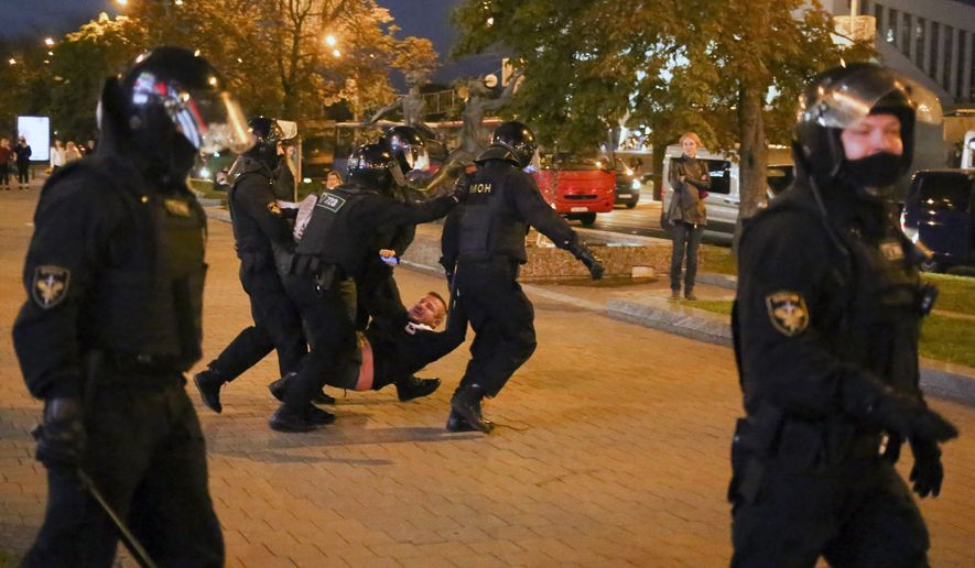 Riot police detain a protester during an opposition rally to protest the presidential inauguration in Minsk, Belarus, Wednesday, Sept. 23, 2020. Belarus President Alexander Lukashenko has been sworn in to his sixth term in office at an inaugural ceremony that was not announced in advance amid weeks of huge protests saying the authoritarian leader's reelection was rigged. Hundreds took to the streets in several cities in the evening to protest the inauguration. (AP Photo/TUT.by)