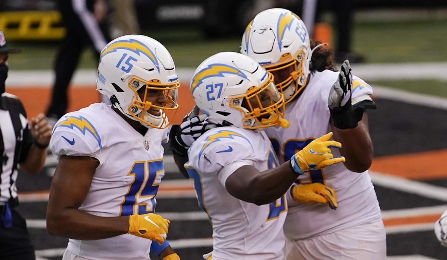 Los Angeles Chargers' Joshua Kelley (27) celebrates with teammates after rushing touchdown during the second half of an NFL football game against the Cincinnati Bengals, Sunday, Sept. 13, 2020, in Cincinnati. (AP Photo/Bryan Woolston)