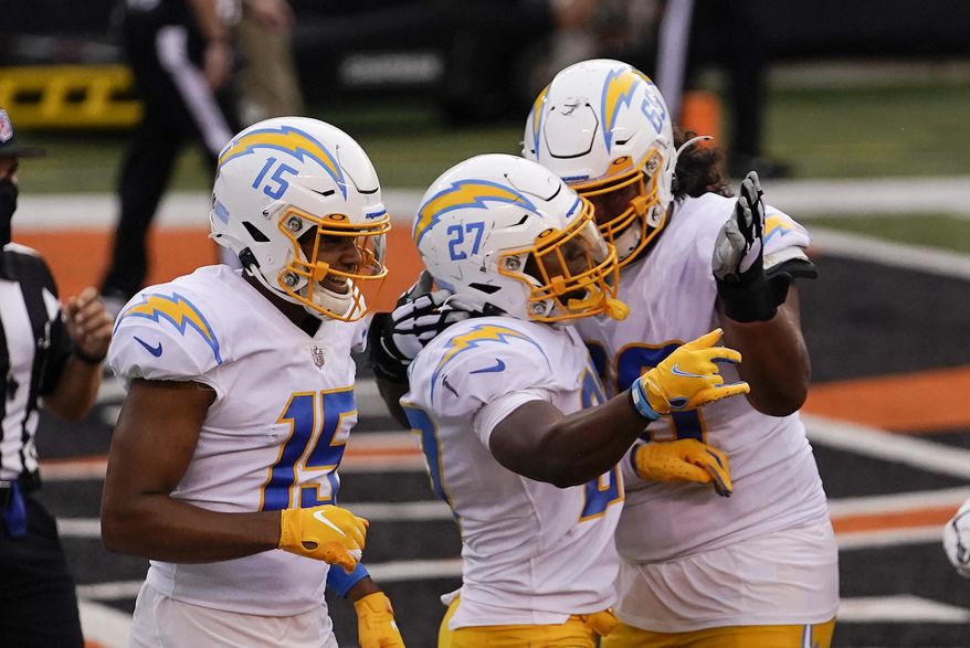 Los Angeles Chargers' Joshua Kelley (27) celebrates with teammates after rushing touchdown during the second half of an NFL football game against the Cincinnati Bengals, Sunday, Sept. 13, 2020, in Cincinnati. (AP Photo/Bryan Woolston)