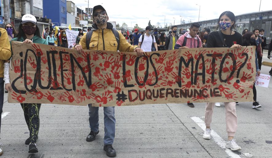 University students march holding a poster with a message that reads in Spanish: &amp;quot;Who killed them?&amp;quot; during a demonstration against a wave of massacres, in Bogota, Colombia, Monday, Sept. 21, 2020. Rather than a national dispute between guerrillas and the state, violence in rural Colombia is now marked by a patchwork of local feuds between criminal groups who fight over drug routes, illegal mines and even gasoline smuggling routes. (AP Photo/Fernando Vergara)