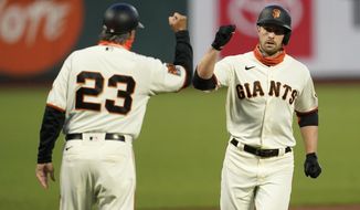 San Francisco Giants&#39; Austin Slater, right, celebrates with third base coach Ron Wotus after hitting a solo home run against the Colorado Rockies during the first inning of a baseball game in San Francisco, Tuesday, Sept. 22, 2020. (AP Photo/Jeff Chiu)