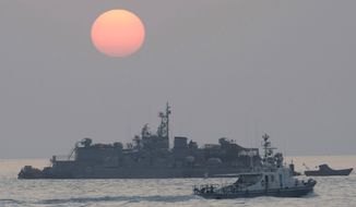In this Dec. 22, 2010, file photo, a government ship sails past the South Korean Navy&#39;s floating base as the sun rises near Yeonpyeong island, South Korea. A South Korean official who disappeared off a government ship near the disputed sea boundary with North Korea this week may be in North Korea, South Korea&#39;s Defense Ministry said Wednesday, Sept. 23, 2020. (AP Photo/Ahn Young-joon, File)