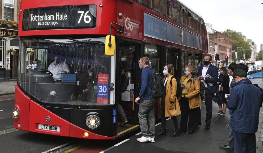 People board a bus outside Waterloo station in London, Wednesday, Sept. 23, 2020, after Prime Minister Boris Johnson announced a range of new restrictions to combat the rise in coronavirus cases in England, Wednesday, Sept. 23, 2020. (Dominic Lipinski/PA via AP)
