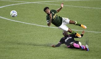 Portland Timbers midfielder Eryk Williamson, left, is upended by Seattle Sounders defender Nouhou Tolo during the first half of an MLS soccer match in Portland, Ore., Wednesday, Sept. 23, 2020. (AP Photo/Steve Dykes)