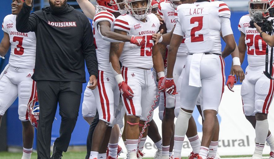 Louisiana running back Elijah Mitchell (15) is surrounded by teammates after he scores the winning touchdown in an overtime play against Georgia State in an NCAA college football game, Saturday, Sept. 19, 2020, in Atlanta. (Daniel Varnado/Atlanta Journal-Constitution via AP)