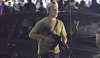 In this Tuesday, Aug. 25, 2020, file photo, Kyle Rittenhouse carries a weapon as he walks along Sheridan Road in Kenosha, Wis., during a night of unrest following the weekend police shooting of Jacob Blake. The way his lawyers tell it, the teenager wasn&#39;t a scared, gun enthusiast in over his head when he fatally shot two protesters. He was a courageous defender of liberty, a patriot exercising his right to bear arms amid chaos in the streets. But some legal experts say Rittenhouse&#39;s lawyers are taking big risks by turning a fairly straightforward self-defense case into a sweeping political argument that mirrors the law-and-order re-election campaign of President Donald Trump. (Adam Rogan/The Journal Times via AP) ** FILE **