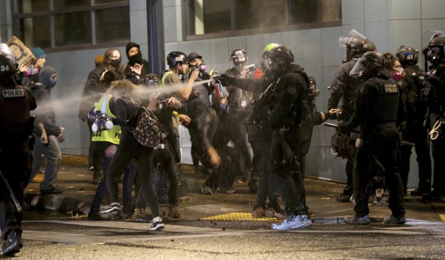 Protesters demanding the end of police violence against Black people are sprayed by police during a demonstration in Portland, Ore., on Wednesday, Sept. 23, 2020. Protesters in Portland hurled Molotov cocktails at officers in Oregon's largest city during a demonstration over a Kentucky grand jury's decision to not indict officers in the fatal shooting of Breonna Taylor, police said Thursday. (Mark Graves/The Oregonian via AP)