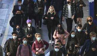 Commuters at Waterloo Station, in London, Thursday, Sept. 24, 2020, after Britain&#39;s Prime Minister Boris Johnson announced a range of new restrictions to combat the rise in coronavirus cases in England. (Victoria Jones/PA via AP)