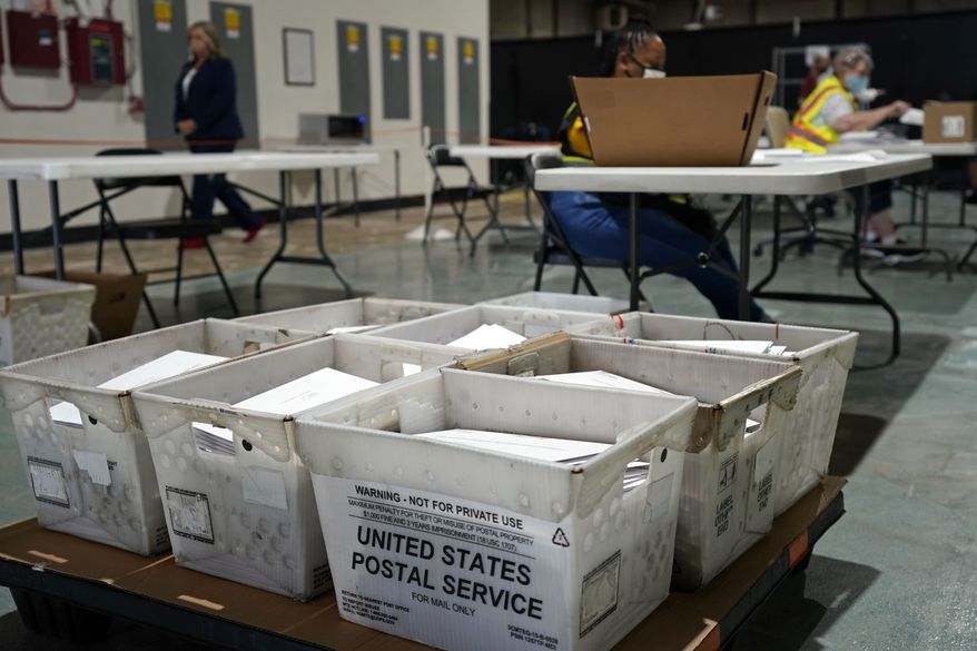 FILE - In this Sept. 3, 2020, file photo, workers prepare absentee ballots for mailing at the Wake County Board of Elections in Raleigh, N.C. The coronavirus pandemic is forcing millions of American voters worried about their health to scramble to vote by mail for the first time. But a requirement in a handful of states, including presidential battleground North Carolina and Wisconsin, that a witness or notary public sign a ballot envelope is tripping up some voters early. (AP Photo/Gerry Broome)