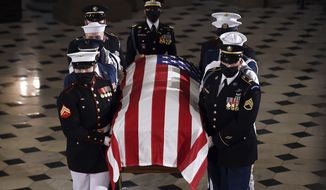 The flag-draped casket of Justice Ruth Bader Ginsburg is carried out by a joint services military honor guard after lying in state at the U.S. Capitol, Friday, Sept. 25, 2020, in Washington.  (Olivier Douliery/Pool via AP)