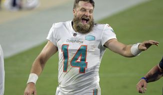Miami Dolphins quarterback Ryan Fitzpatrick laughs with coaches as he comes off the field after defeating the Jacksonville Jaguars in an NFL football game, Thursday, Sept. 24, 2020, in Jacksonville, Fla. (AP Photo/Phelan M. Ebenhack)