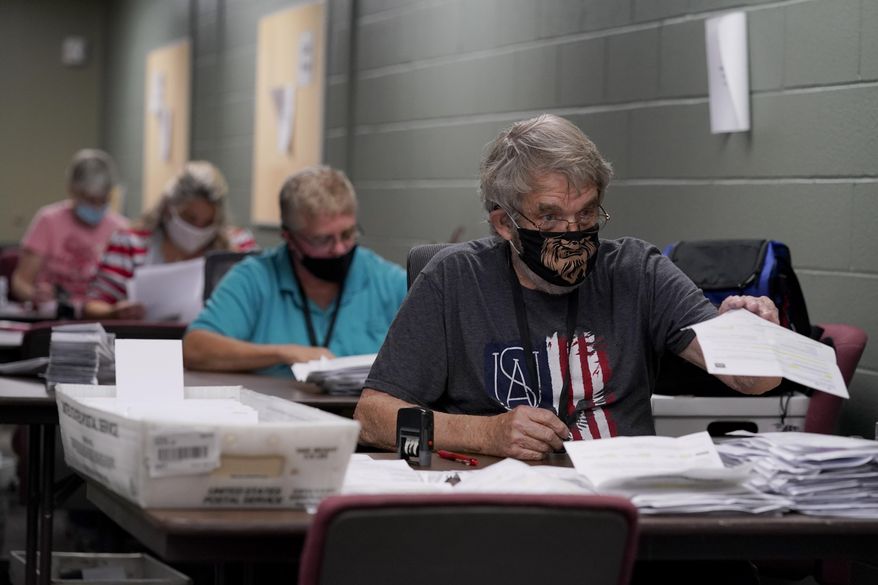 Election workers open and sort mail-in ballot requests Tuesday, Sept. 22, 2020, at the Johnson County election office in Olathe, Kan. The office has processed more than 100,000 mail-in ballot requests so far as more people than normal are expected to vote by mail due to concerns about the coronavirus. (AP Photo/Charlie Riedel)