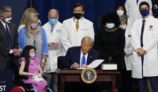 President Donald Trump signs an executive order after delivering remarks on healthcare at Charlotte Douglas International Airport, Thursday, Sept. 24, 2020, in Charlotte, N.C. (AP Photo/Chris Carlson)