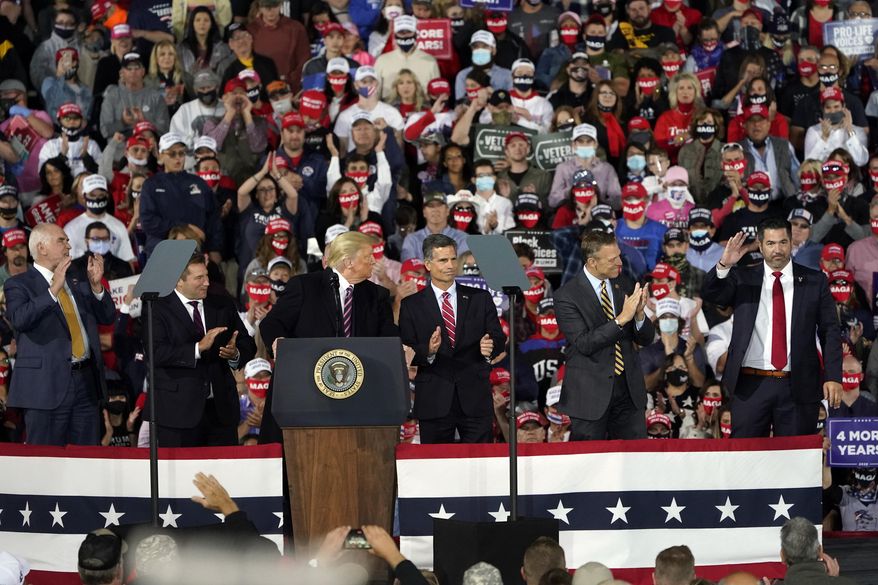 President Donald Trump looks over at Pennsylvania congressional candidate, right, as he speaks at a campaign rally, Tuesday, Sept. 22, 2020, in Moon Township, Pa. (AP Photo/Keith Srakocic)