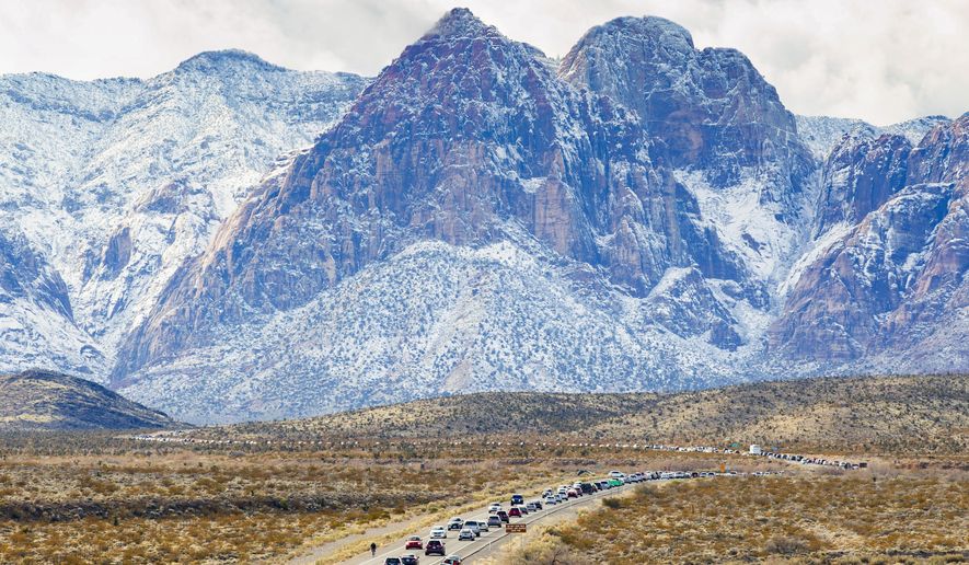 This photo by Yasmina Chavez of the Las Vegas Sun, of vehicles lined up to enter the snow-covered Red Rock Canyon following some cold and rainy weather on Dec. 27, 2019, won Photo of the Year honors from the Nevada Press Association Thursday, Sept. 24, 2020. (Yasmina Chavez/Las Vegas Sun via AP)