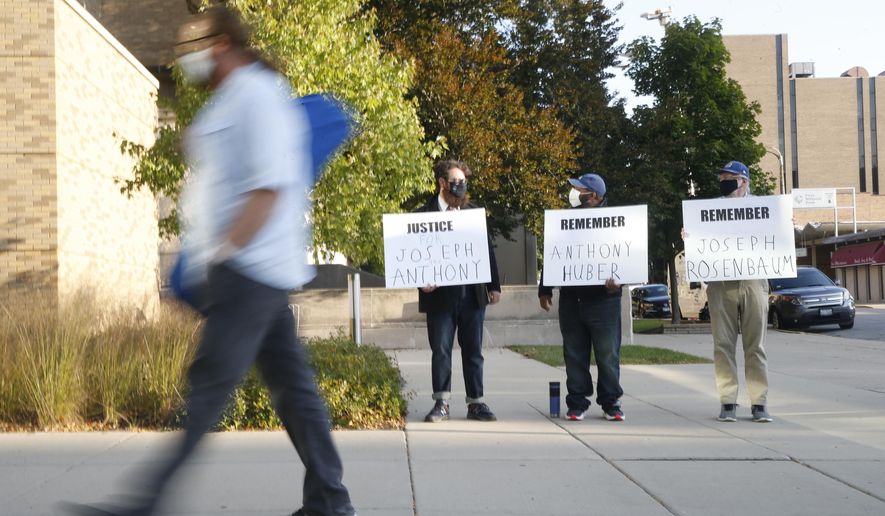 From left, Matt Muchowski,  Vance Wyatt, and Donald Blake hold signs outside the Lake County Courthouse in Waukegan, Ill.,  Friday, Sept. 25, 2020.   Kyle Rittenhouse, accused of killing two protesters days after Jacob Blake was shot by police in Kenosha, Wis., faces a hearing to return him to Wisconsin to face trial on homicide charges that could put him in prison for life. (Stacey Wescott/Chicago Tribune via AP)