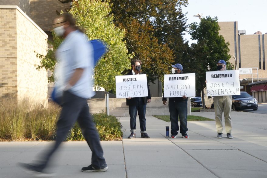 From left, Matt Muchowski, Vance Wyatt, and Donald Blake hold signs outside the Lake County Courthouse in Waukegan, Ill., Friday, Sept. 25, 2020. Kyle Rittenhouse, accused of killing two protesters days after Jacob Blake was shot by police in Kenosha, Wis., faces a hearing to return him to Wisconsin to face trial on homicide charges that could put him in prison for life. (Stacey Wescott/Chicago Tribune via AP)