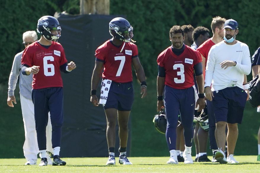 Seattle Seahawks quarterbacks Russell Wilson (3), Geno Smith (7) and Anthony Gordon (6) walk with offensive coordinator Brian Schottenheimer, right, and head coach Pete Carroll, left, following the last day of NFL football training camp, Thursday, Sept. 3, 2020, in Renton, Wash. (AP Photo/Ted S. Warren)