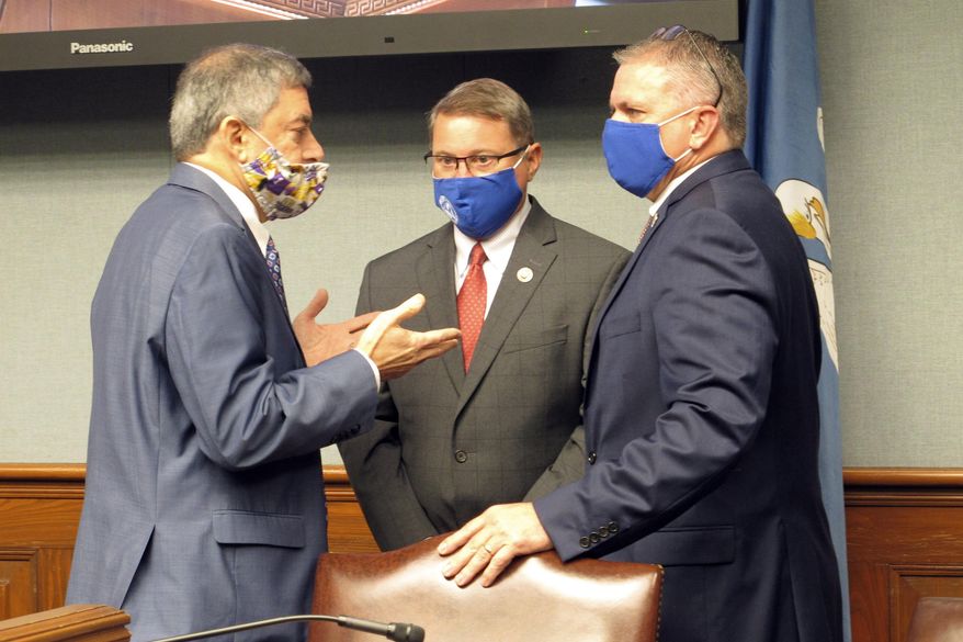 Commissioner of Administration Jay Dardenne, left, the governor's chief budget adviser, speaks with Senate President Page Cortez, R-Lafayette, center, and House Speaker Clay Schexnayder, R-Gonzales, right, on Friday, Sept. 25, 2020, in Baton Rouge, La. The three men, all members of the Revenue Estimating Conference, spoke ahead of the conference's meeting. (AP Photo/Melinda Deslatte)