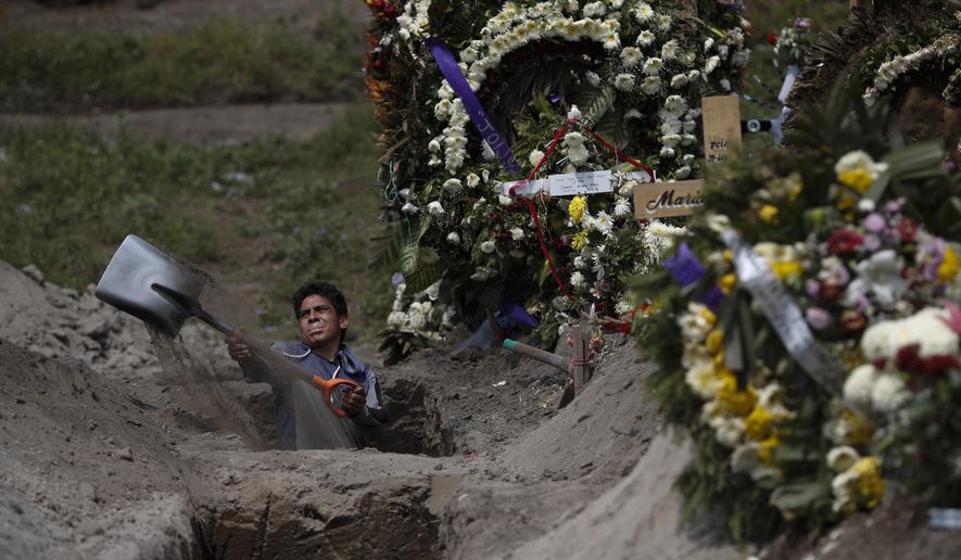 A cemetery worker digs a grave in a section of the Valle de Chalco Municipal Cemetery which opened early in the coronavirus pandemic to accommodate the surge in deaths, on the outskirts of Mexico City, Thursday, Sept. 24, 2020.(AP Photo/Rebecca Blackwell)