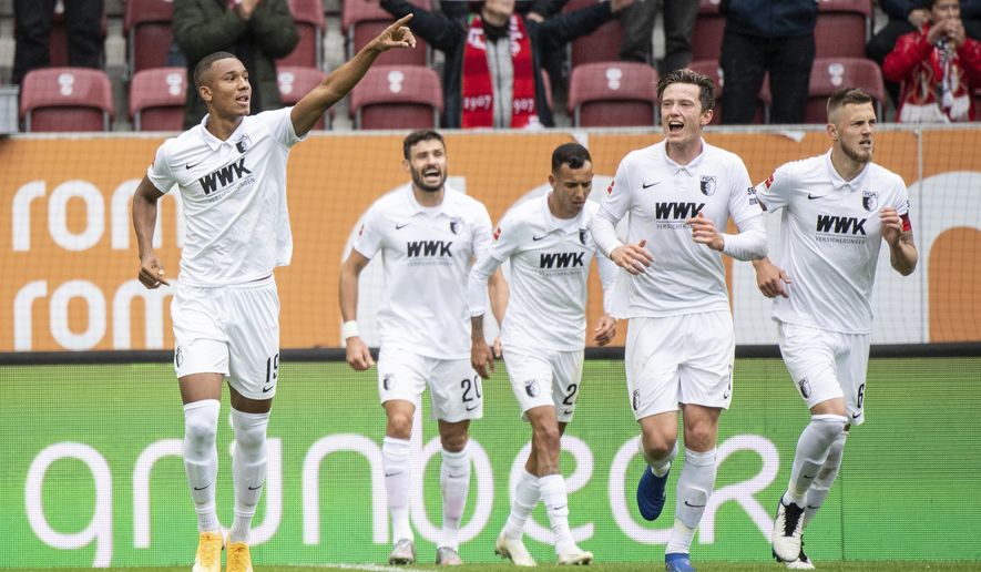 Felix Uduokhai of Augsburg, left, cheers for his goal during the German Bundesliga soccer match between FC Augsburg and Borussia Dortmund in Augsburg, Germany, Saturday, Sept. 26, 2020. (Matthias Balk/dpa via AP)