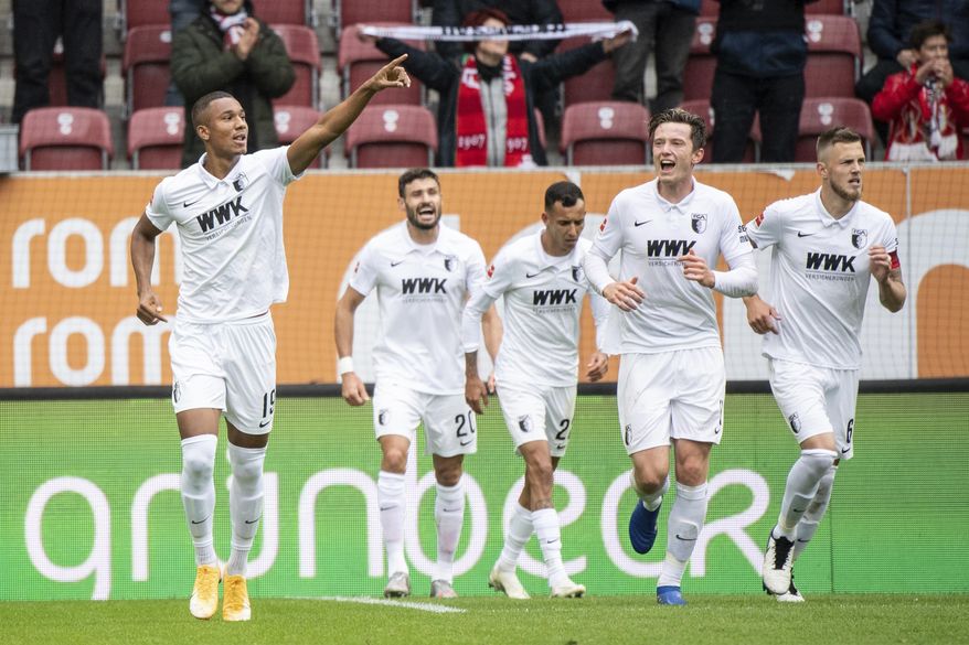 Felix Uduokhai of Augsburg, left, cheers for his goal during the German Bundesliga soccer match between FC Augsburg and Borussia Dortmund in Augsburg, Germany, Saturday, Sept. 26, 2020. (Matthias Balk/dpa via AP)