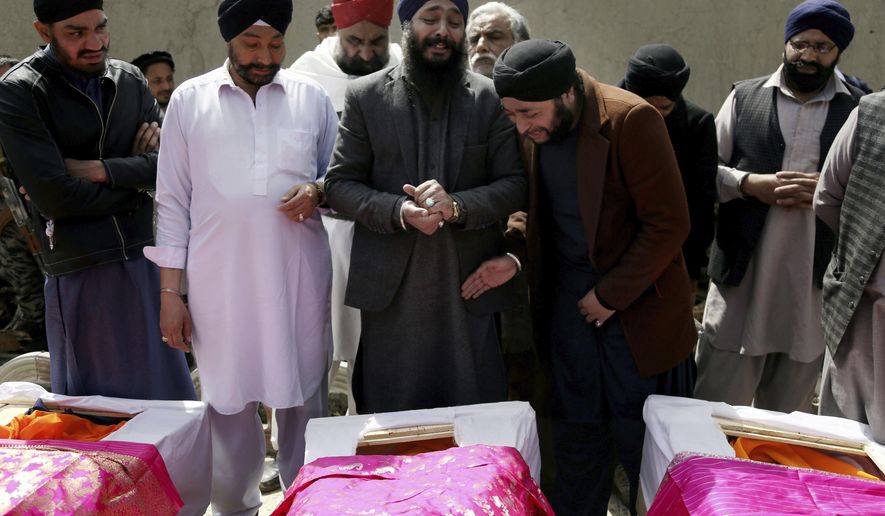 FILE- in this Thursday, March 26, 2020 file photo, Afghan Sikh men mourn their beloved ones during a funeral procession for those who were killed on Wednesday by a lone Islamic State gunman, rampaged through a Sikh house of worship, in Kabul, Afghanistan. Afghanistan’s dwindling community of Sikhs and Hindus is shrinking to its lowest levels. With growing threats from the local Islamic State affiliate, many are choosing to leave the country of their birth to escape the insecurity and a once-thriving community of as many as 250,000 members now counts fewer than 700.  (AP Photo/Tamana Sarwary, File)
