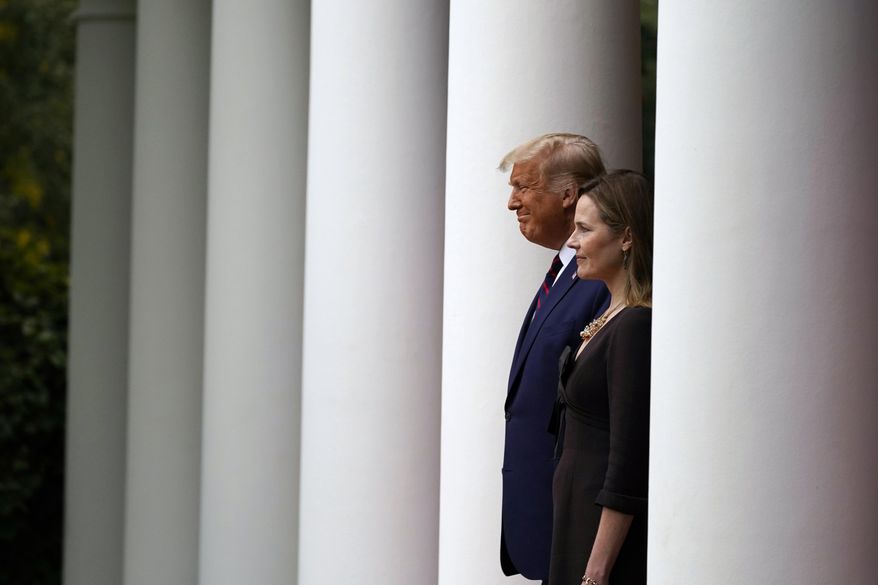President Donald Trump walks with Judge Amy Coney Barrett to a news conference to announce Barrett as his nominee to the Supreme Court, in the Rose Garden at the White House, Saturday, Sept. 26, 2020, in Washington. (AP Photo/Alex Brandon)