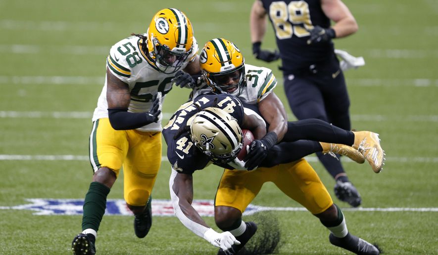New Orleans Saints running back Alvin Kamara (41) is tackled by Green Bay Packers strong safety Adrian Amos (31) and inside linebacker Christian Kirksey (58) on a 49 yard run in the first half of an NFL football game in New Orleans, Sunday, Sept. 27, 2020. (AP Photo/Brett Duke)