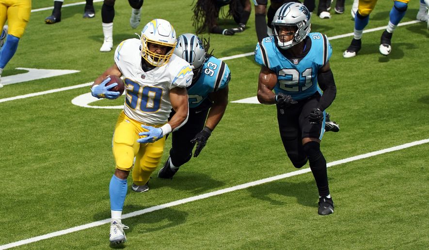 Los Angeles Chargers running back Austin Ekeler (30) runs for a touchdown past Carolina Panthers free safety Tre Boston (33) and outside linebacker Jeremy Chinn (21) during the first half of an NFL football game Sunday, Sept. 27, 2020, in Inglewood, Calif. (AP Photo/Ashley Landis )