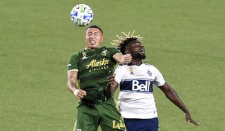 Portland Timbers midfielder Marvin Loria, left, and Vancouver Whitecaps midfielder Leonard Owusu compete for the ball during the first half of an MLS soccer match in Portland, Ore., Sunday, Sept. 27, 2020. (AP Photo/Steve Dykes)
