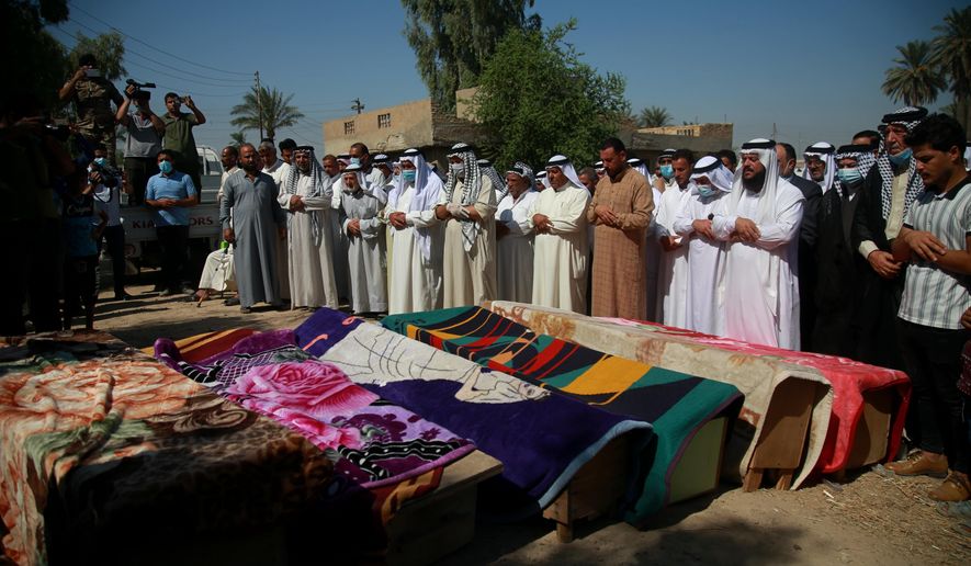 Mourners pray over the coffins of civilians killed by a Katyusha rocket attack near the international airport in Baghdad, Iraq, Tuesday, Sept. 29, 2020. Several Iraqi civilians were killed and two severely wounded Monday after the rocket hit near Baghdad airport, Iraq&#x27;s military said. It was the first time in months an attack caused civilian casualties.(AP Photo/Khalid Mohammed)