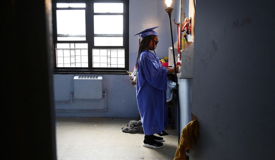 FILE - In this Friday, Aug. 21, 2020, file photo, Maddison Washington, 11, stands at her bedroom mirror as she gets ready for her virtual graduation from her Brooklyn middle school, in the Brooklyn borough of New York. After being delayed twice, hundreds of thousands of elementary school students are heading back to classrooms Tuesday, Sept. 29 as New York City enters a high-stakes phase of resuming in-person learning during the coronavirus pandemic. (AP Photo/Jessie Wardarski, File)