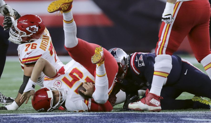 FILE - In this Sunday, Dec. 8, 2019, file photo, Kansas City Chiefs quarterback Patrick Mahomes lands on the turf after he was sacked by New England Patriots defensive tackle Adam Butler, right rear, in the first half of an NFL football game in Foxborough, Mass. In three previous meetings with Kansas City's Patrick Mahomes, the Patriots defense has had its most success when it's been able to force turnovers and get pressure on him. But that's easier said than done against a quarterback who has yet commit a turnover this season and is completing a career-high 68% of his passes.(AP Photo/Charles Krupa, File)
