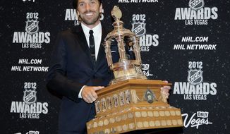 FILE - In this June 20, 2012, file photo, New York Rangers&#39; Henrik Lundqvist poses with the Vezina Trophy after winning the award for the league&#39;s best goalie during the NHL Awards in Las Vegas. The New York Rangers have bought out the contract of star goaltender Henrik Lundqvist. The Rangers parted with one of the greatest netminders in franchise history on Wednesday, Sept. 30, 2020, when they paid off the final year of his contract.(AP Photo/Julie Jacobson, File)
