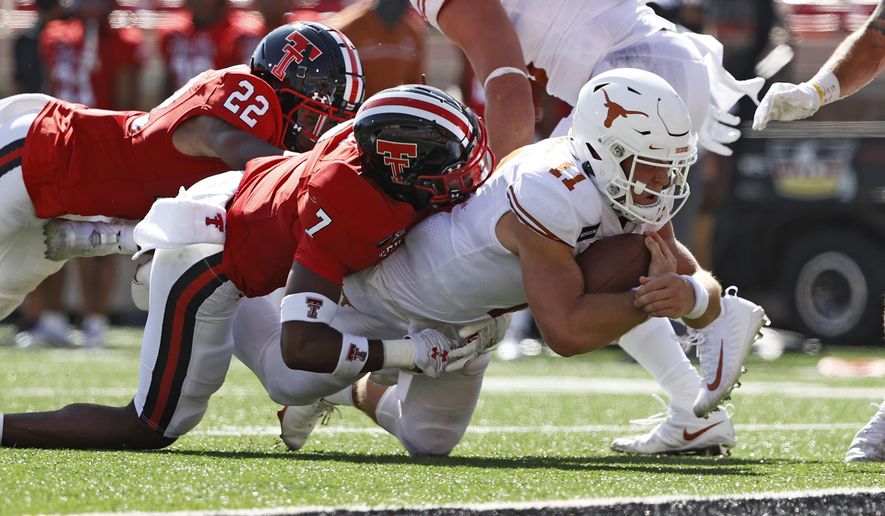 Texas' Sam Ehlinger (11) is tackled by Texas Tech's Adrian Frye (7) short of the goal line during the first half of an NCAA college football game Saturday, Sept. 26, 2020, in Lubbock, Texas. (Brad Tollefson/Lubbock Avalanche-Journal via AP)
