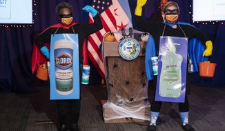Chicago Mayor Lori Lightfoot, left,  and Dr. Allison Arwady, commissioner of the Chicago Department of Public Health, wear &quot;Rona Destroyer&quot; costumes as they pose a press conference about Halloween at City Hall, Thursday afternoon, Oct. 1, 2020, in Chicago. City officials say Chicagoans going door-to-door on Halloween this year will have to wear masks and keep groups small to minimize risks of the coronavirus. (Ashlee Rezin Garcia/Chicago Sun-Times via AP)