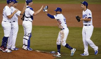 The Los Angeles Dodgers celebrate a 4-2 win over the Milwaukee Brewers in Game 1 of a National League wild-card baseball series Wednesday, Sept. 30, 2020, in Los Angeles. (AP Photo/Ashley Landis)