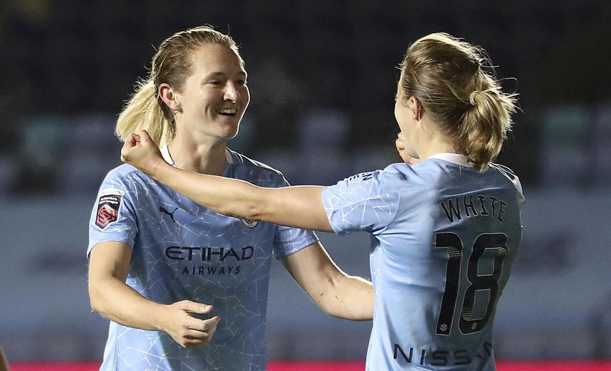 Manchester City's Sam Mewis, left, celebrates with teammmate Ellen White, after scoring her team's second goal, during the Women's FA Cup semi final soccer match between Manchester City and Arsenal, at the Academy Stadium, in Manchester, England, Thursday, Oct. 1, 2020. (Martin Rickett/PA via AP)